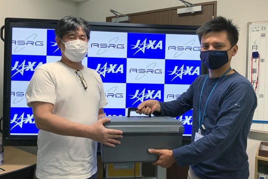 Dr. Nakamura (left)received the sample（C）JAXA