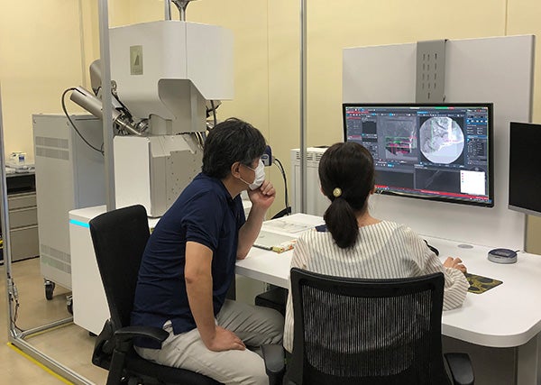 Dr. Nakamura(left) analyzes the samples using Xe plasma FIB-SEM at Keio-TOYO Nano Imaging Center